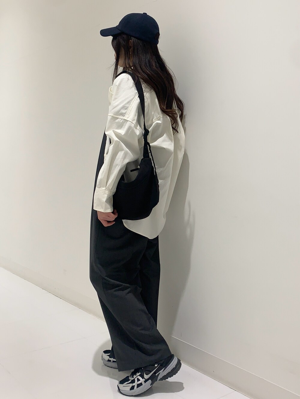 ブルー系のニット/セーター、ホワイト系のシャツ/ブラウス、グレー系のサロペット/オーバーオールを着用したレディースの冬コーディネートの2枚目の写真