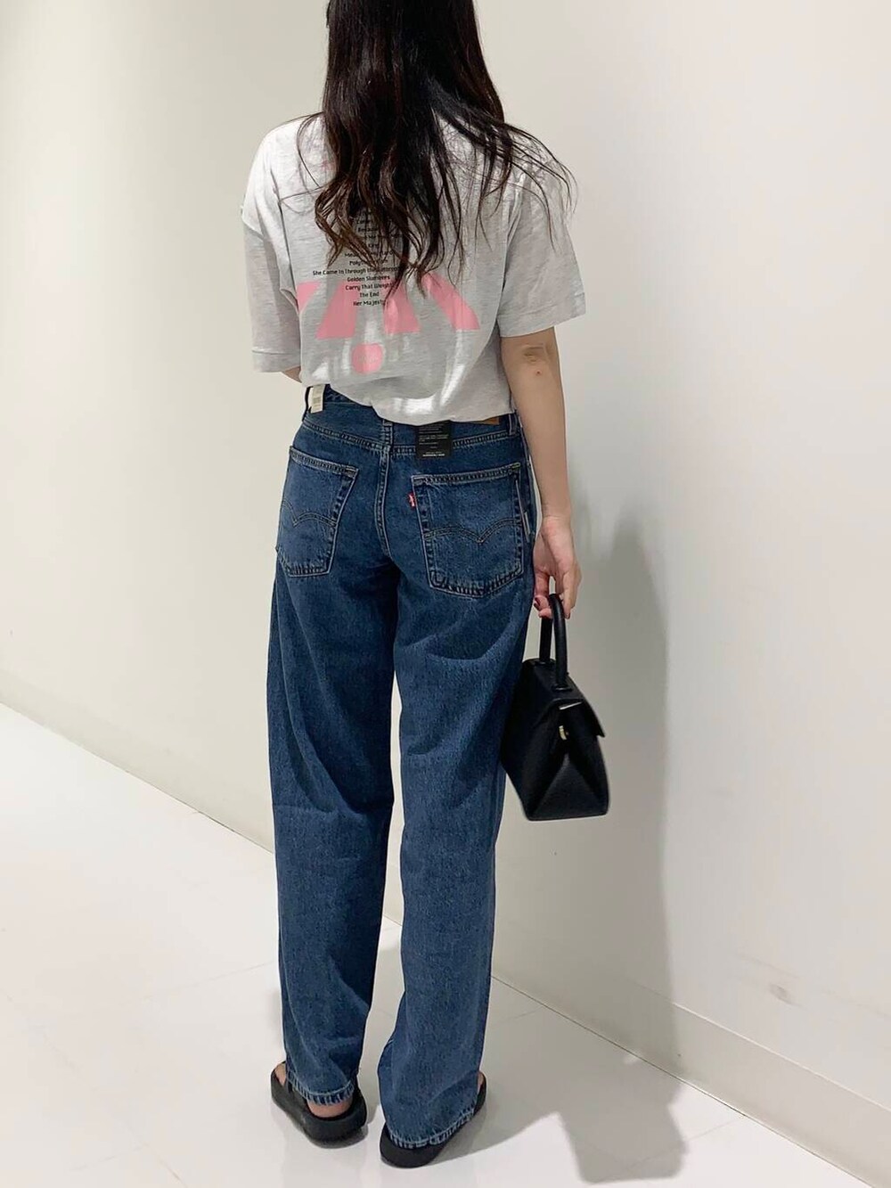 グレー系のTシャツ/カットソー、ブルー系のデニムパンツ、ブラック系のショルダーバッグを着用したレディースの夏コーディネートの4枚目の写真