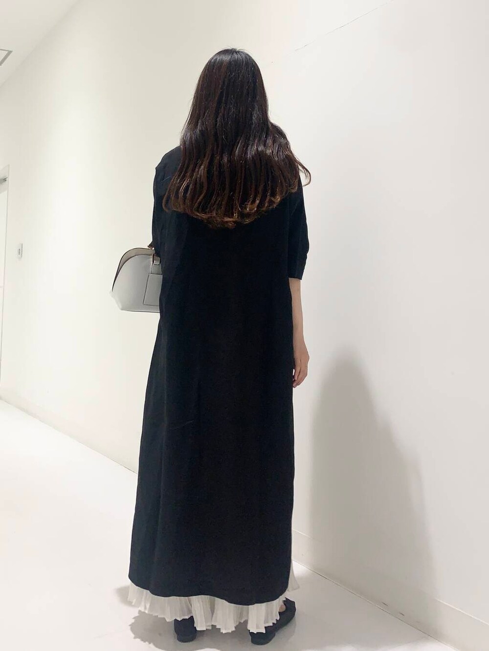 ブラック系のワンピース、ホワイト系のハンドバッグ、ブラック系のバレエシューズを着用したレディースの春コーディネートの3枚目の写真