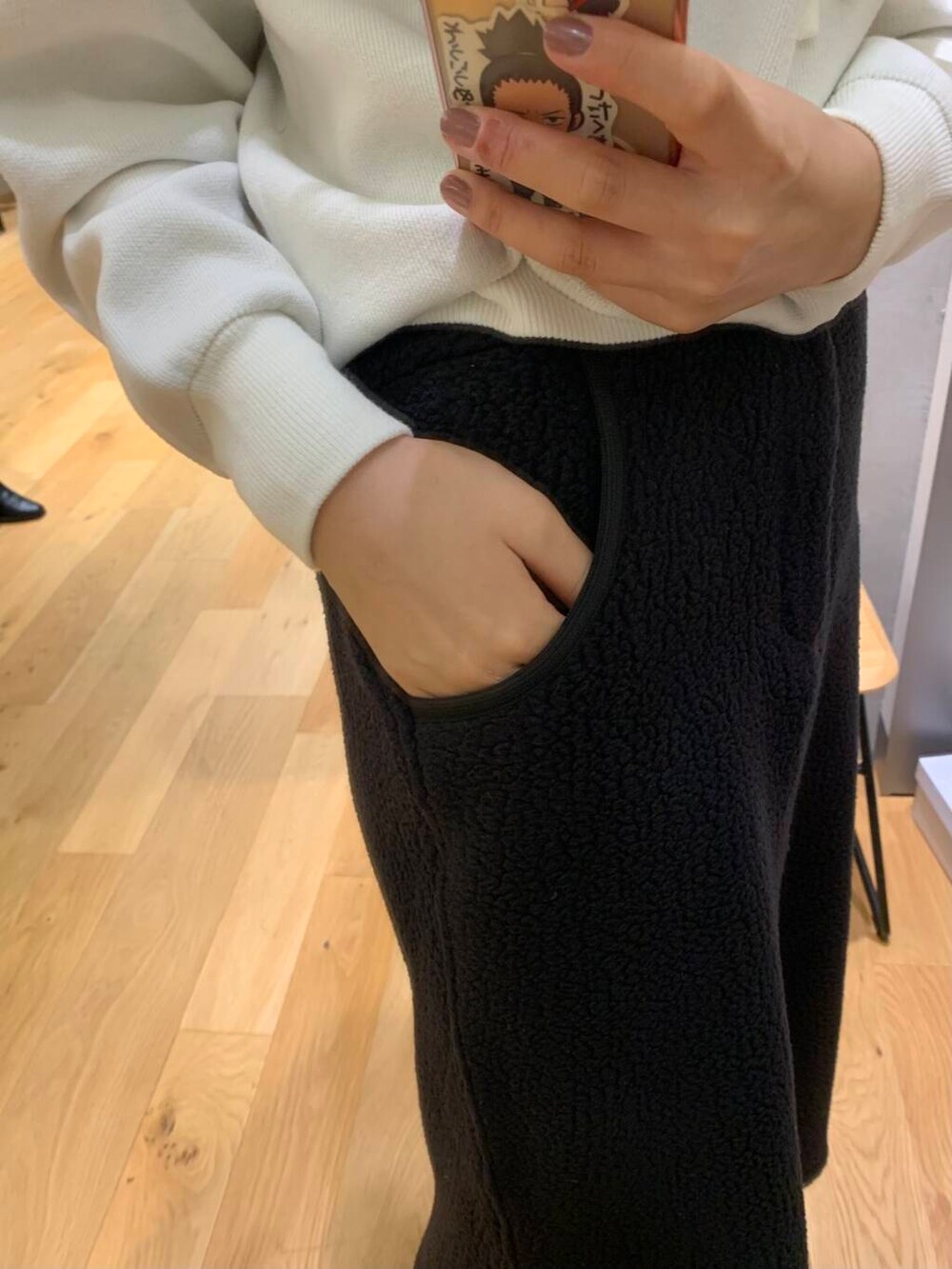 ブラウン系のダウンジャケット/コート、ブラック系のブーツ、ホワイト系のパーカーを着用したレディースの秋コーディネートの4枚目の写真