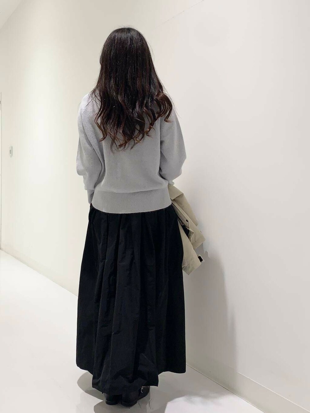 ブラック系のトートバッグ、ベージュ系のダウンジャケット/コート、ブルー系のニット/セーターを着用したレディースの冬コーディネートの6枚目の写真