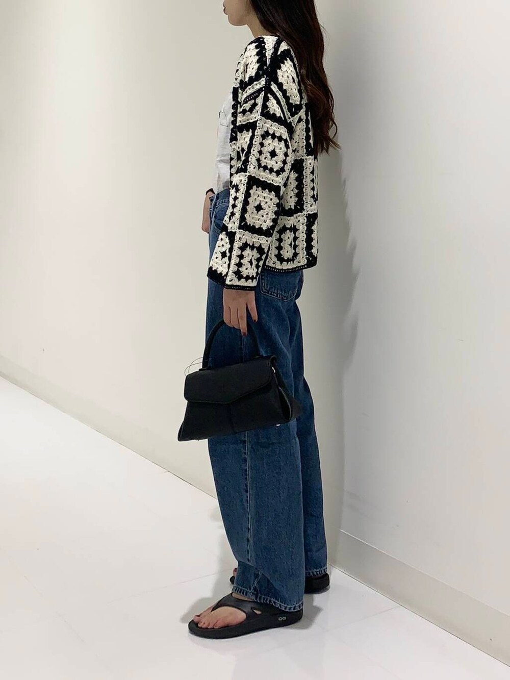 グレー系のTシャツ/カットソー、ブルー系のデニムパンツ、ブラック系のショルダーバッグを着用したレディースの夏コーディネートの2枚目の写真