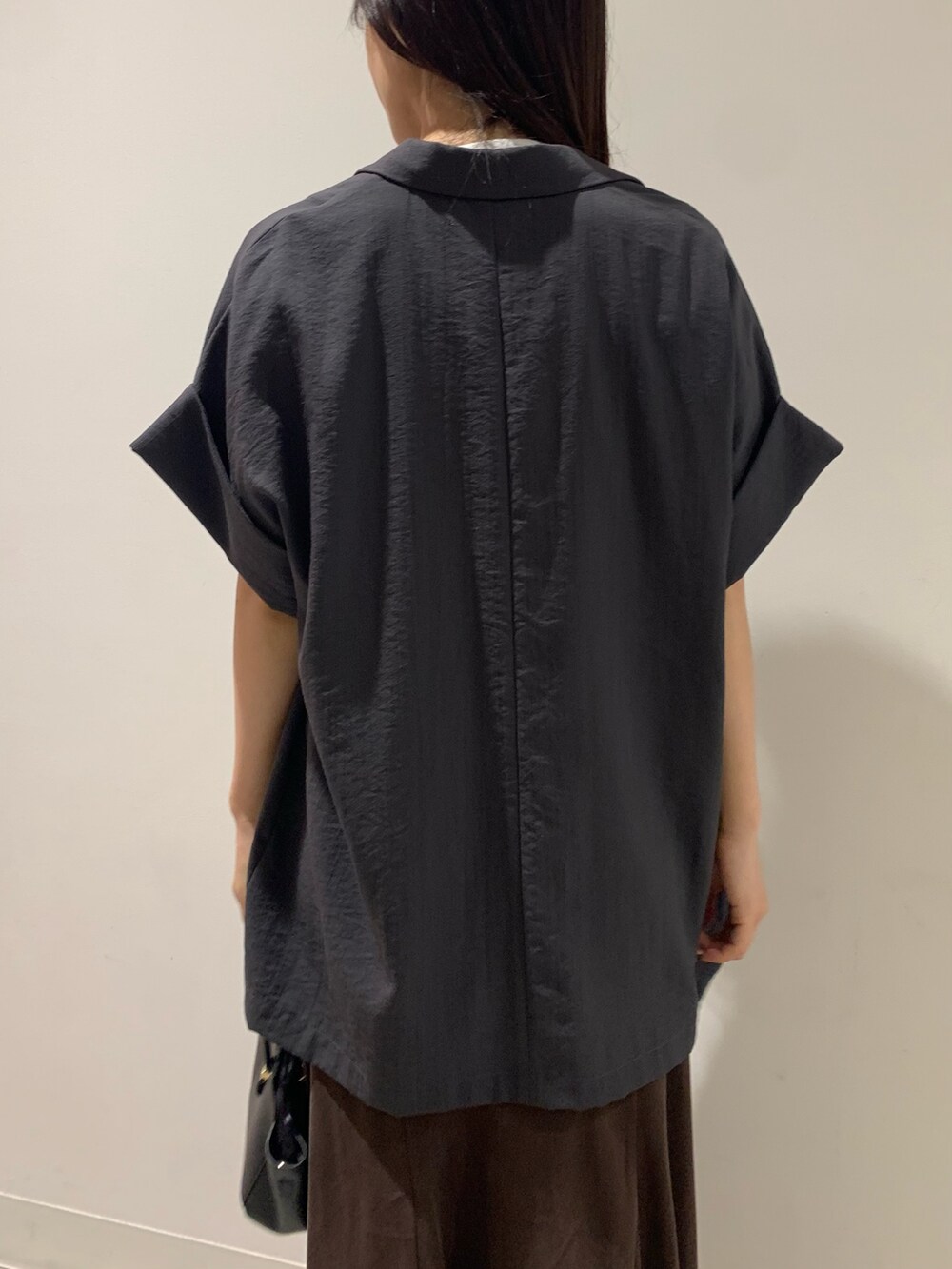 グレー系のテーラードジャケット、ブラウン系のスカート、ホワイト系のTシャツ/カットソーを着用したレディースの夏コーディネートの10枚目の写真