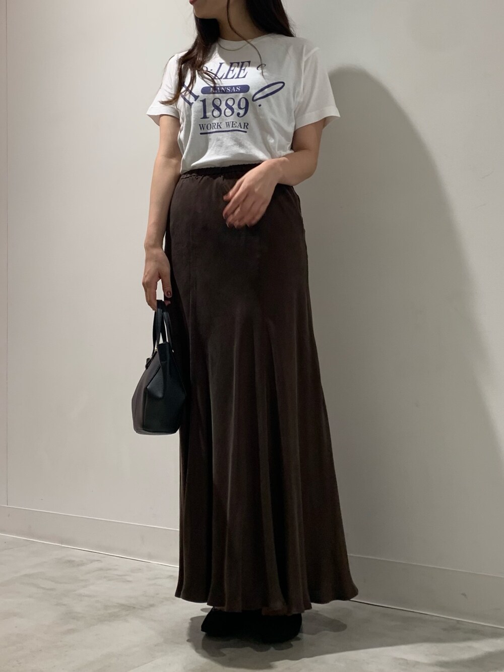 グレー系のテーラードジャケット、ブラウン系のスカート、ホワイト系のTシャツ/カットソーを着用したレディースの夏コーディネートの4枚目の写真