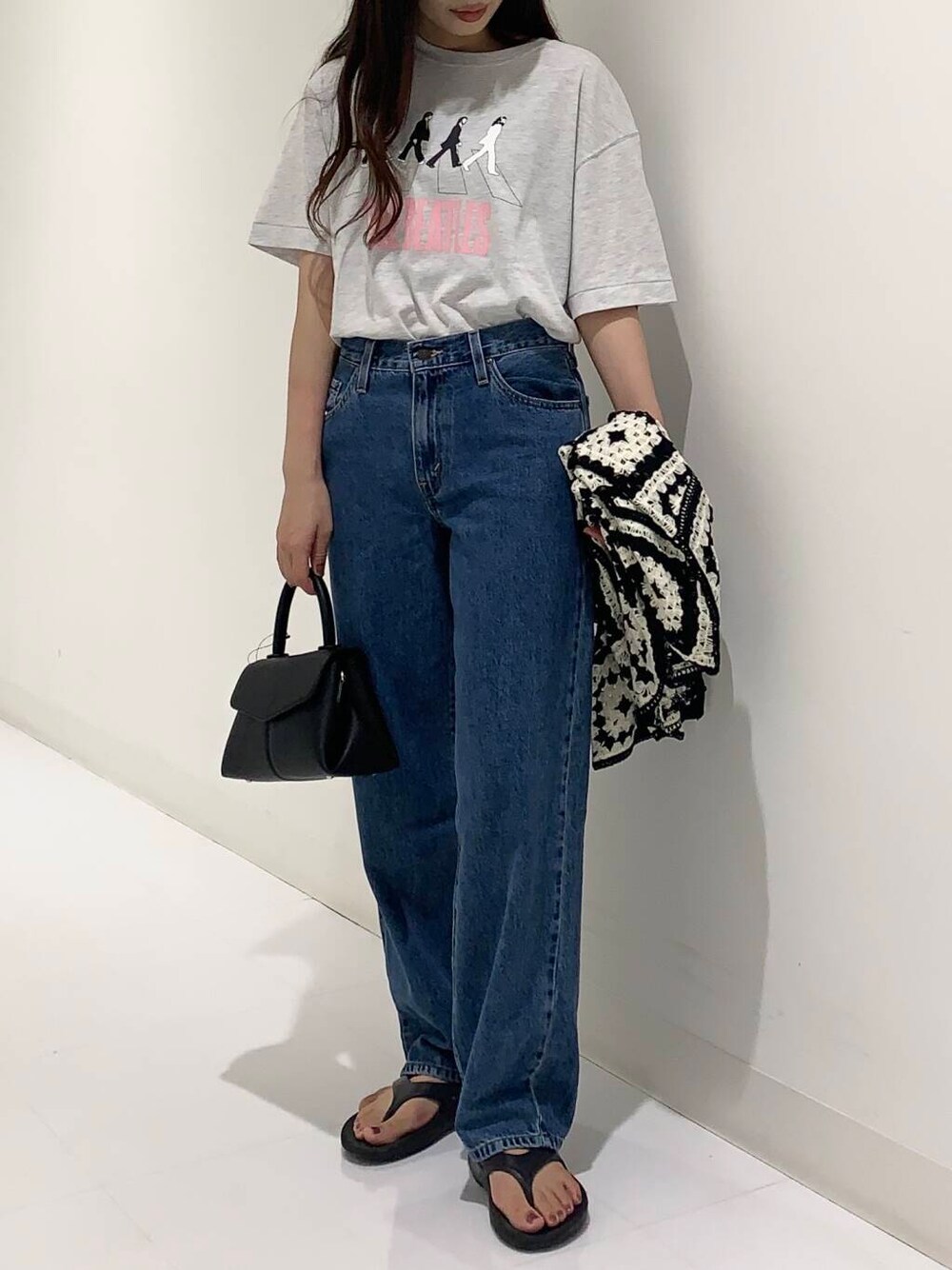 グレー系のTシャツ/カットソー、ブルー系のデニムパンツ、ブラック系のショルダーバッグを着用したレディースの夏コーディネートの3枚目の写真