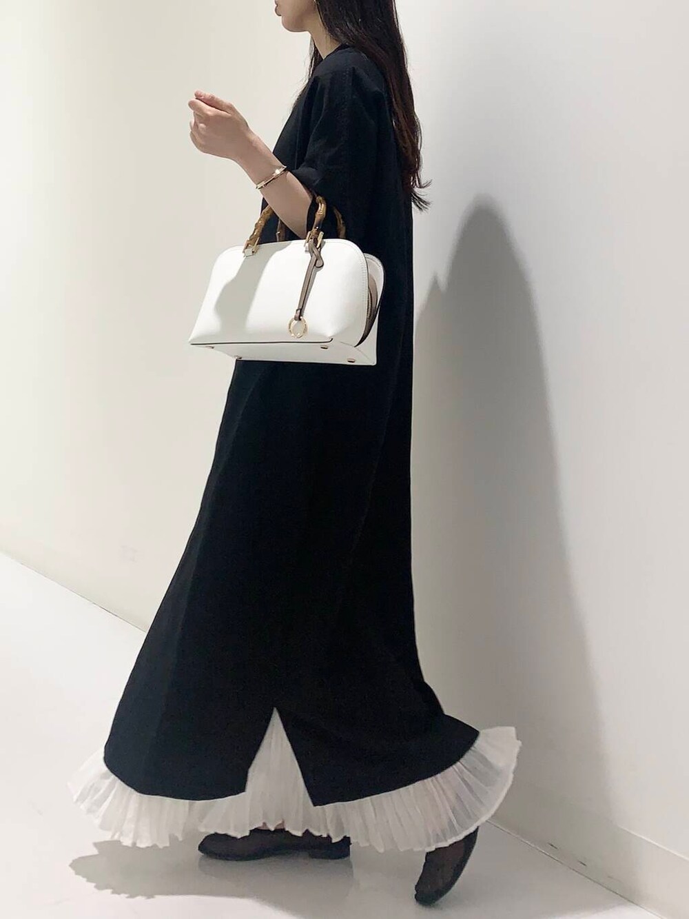 ブラック系のワンピース、ホワイト系のハンドバッグ、ブラック系のバレエシューズを着用したレディースの春コーディネートの2枚目の写真