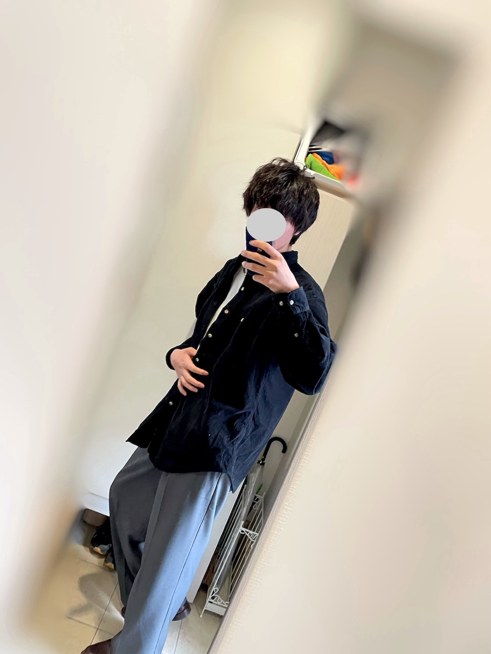 ブラック系のトップス、グレー系のスラックス、ブラウン系のシューズを着用したメンズの春コーディネートの2枚目の写真