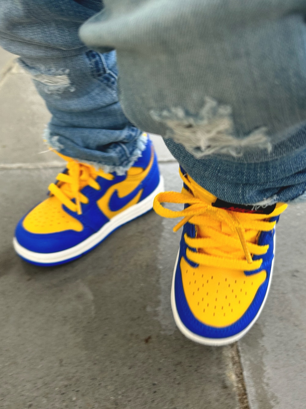 ブラック系のパーカー、ブルー系のデニムパンツ、ブルー系のスニーカーを着用したキッズの春コーディネートの3枚目の写真