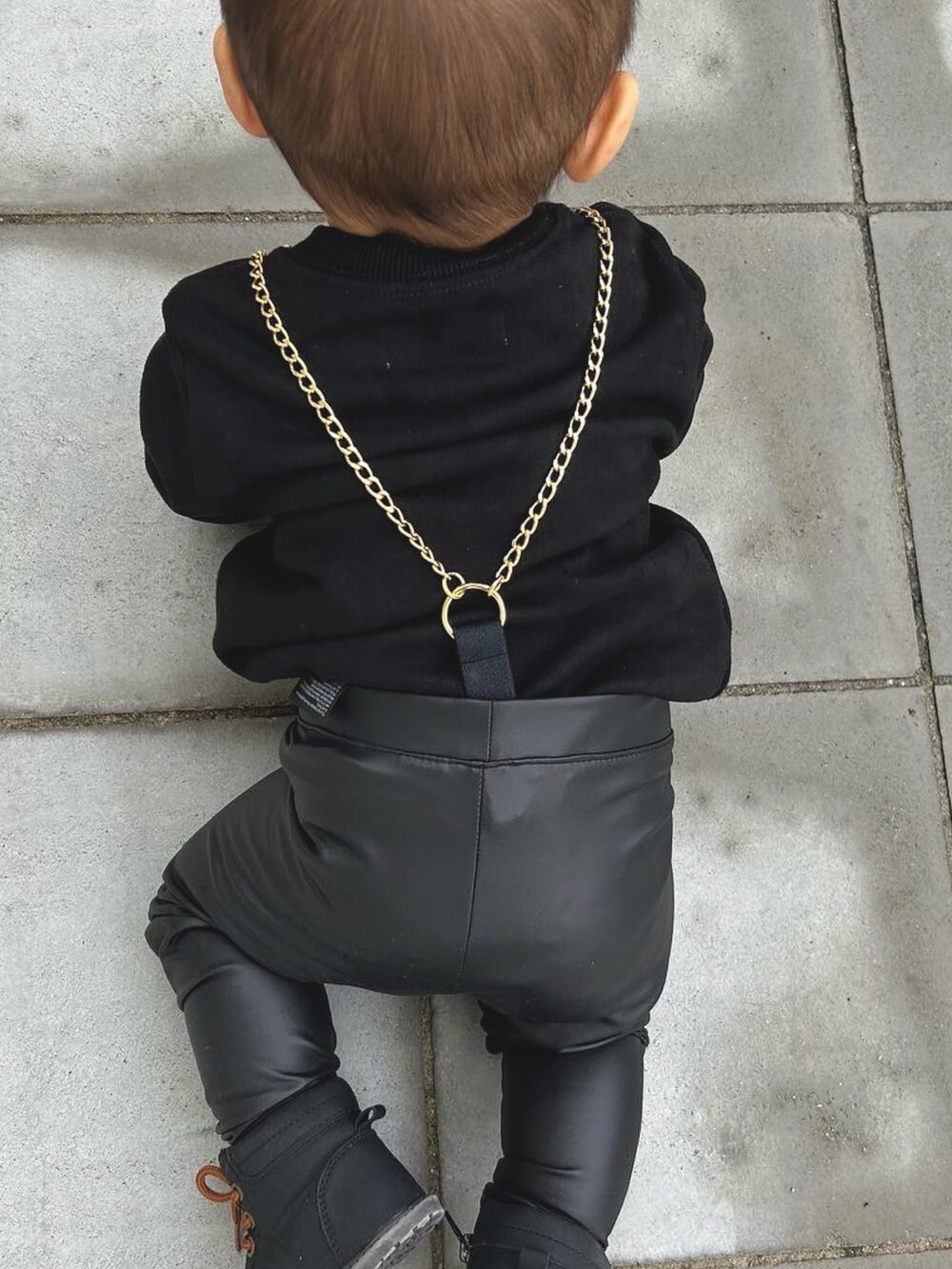 ブラック系のトップス、ブラック系のパンツ、ブラック系のベビーシューズ/ベビーソックスを着用したキッズの春コーディネートの3枚目の写真