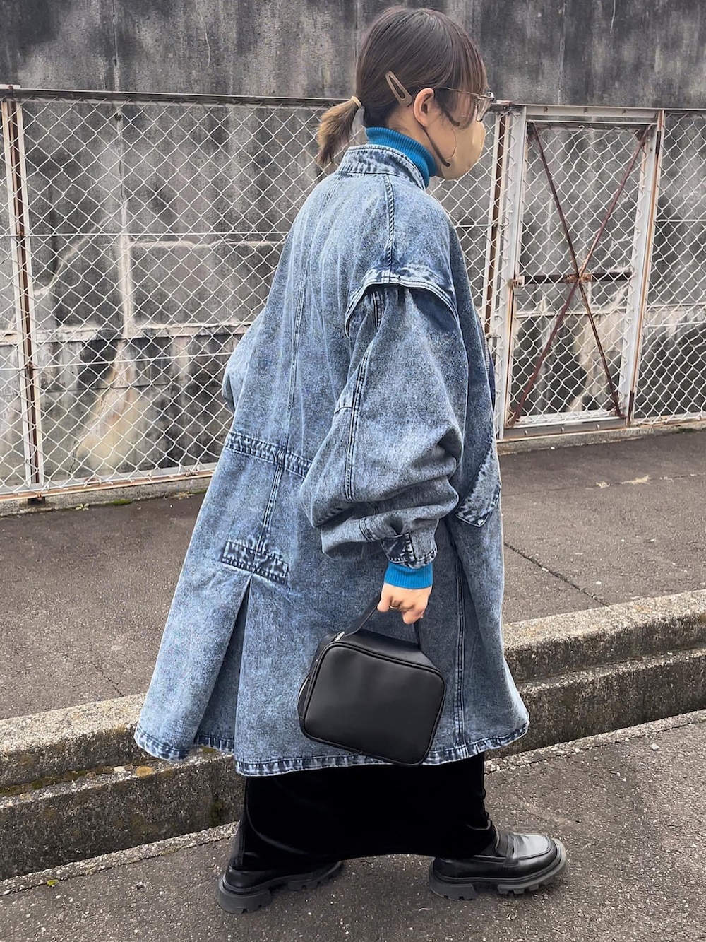 ブラック系のボストンバッグ、ブラック系のスカート、ブルー系のモッズコートを着用したレディースの冬コーディネートの2枚目の写真