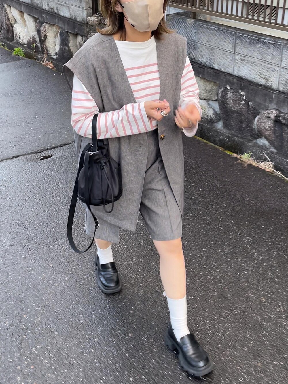 ブラック系のバッグ、グレー系のセットアップ、ピンク系のトップスを着用したレディースの春コーディネートの4枚目の写真