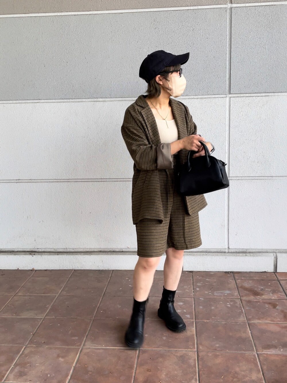 ブラック系のボストンバッグ、ベージュ系のテーラードジャケット、ベージュ系のその他パンツを着用したレディースの秋コーディネートの4枚目の写真