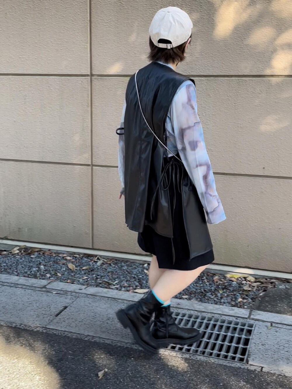 ブラック系のベスト、ブルー系のTシャツ/カットソー、ベージュ系のキャップを着用したレディースの秋コーディネートの5枚目の写真