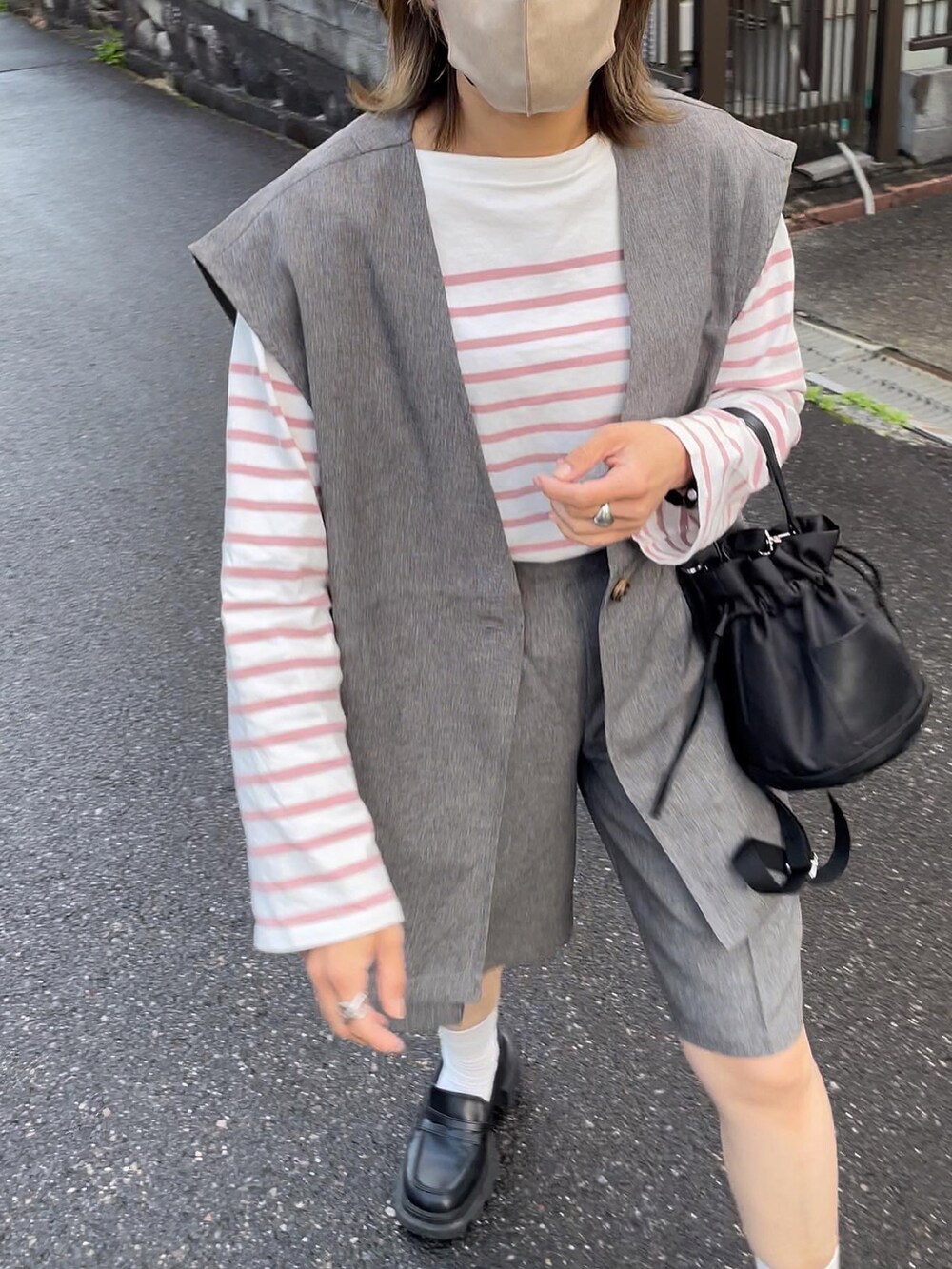 ブラック系のバッグ、グレー系のセットアップ、ピンク系のトップスを着用したレディースの春コーディネートの5枚目の写真