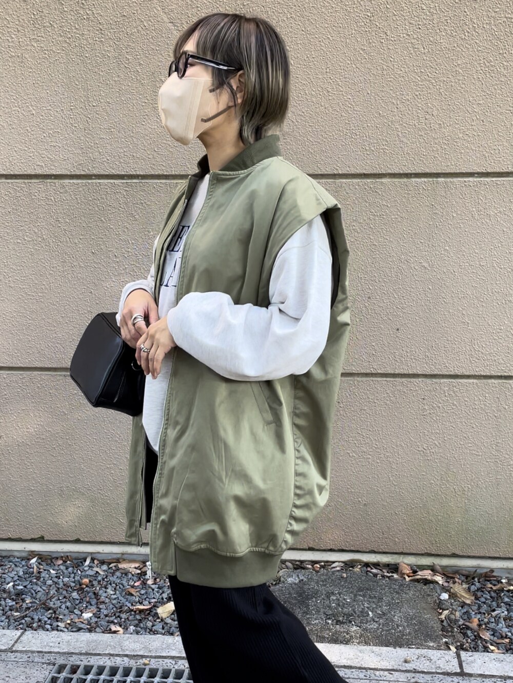 グリーン系のMA-1、ブラック系のスカート、ブラック系のボストンバッグを着用したレディースの秋コーディネートの4枚目の写真