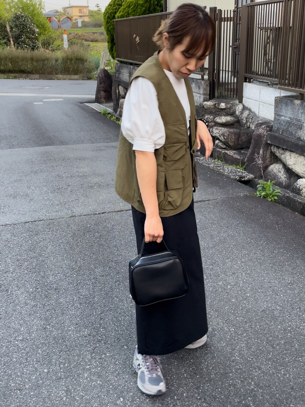 ブラック系のハンドバッグ、ホワイト系のTシャツ/カットソー、グリーン系のその他アウターを着用したレディースの春コーディネートの4枚目の写真