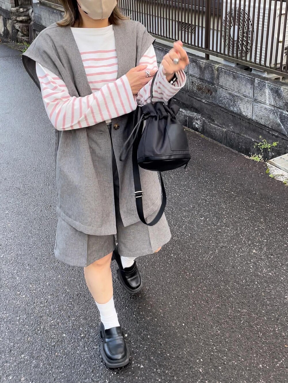 ブラック系のバッグ、グレー系のセットアップ、ピンク系のトップスを着用したレディースの春コーディネートの3枚目の写真