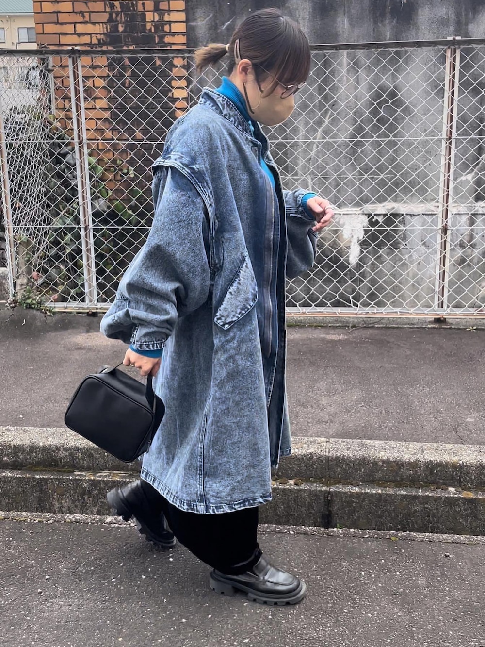 ブラック系のボストンバッグ、ブラック系のスカート、ブルー系のモッズコートを着用したレディースの冬コーディネートの4枚目の写真