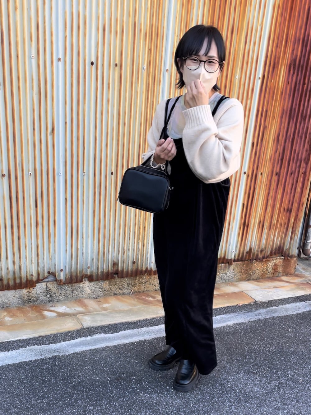 ブラック系のワンピース、ブラック系のブーツ、ブラック系のボストンバッグを着用したレディースの秋コーディネートの3枚目の写真