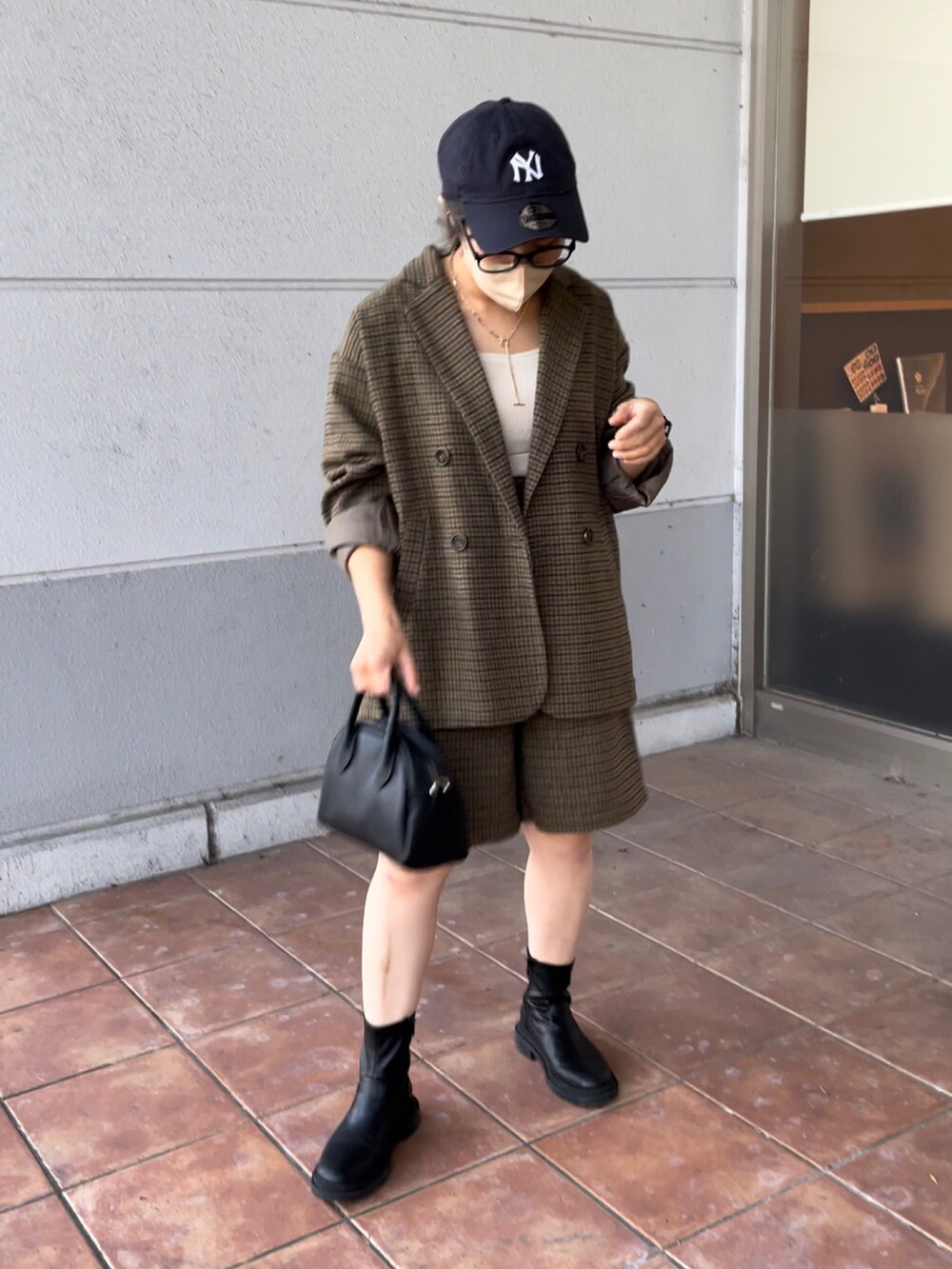 ブラック系のボストンバッグ、ベージュ系のテーラードジャケット、ベージュ系のその他パンツを着用したレディースの秋コーディネートの5枚目の写真