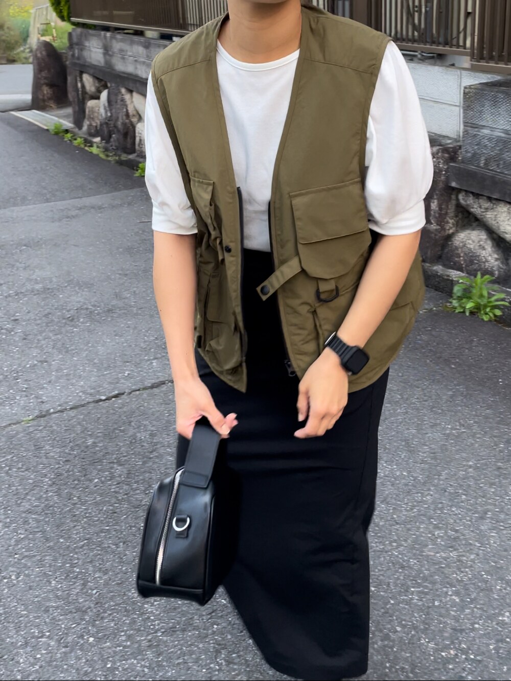 ブラック系のハンドバッグ、ホワイト系のTシャツ/カットソー、グリーン系のその他アウターを着用したレディースの春コーディネートの3枚目の写真