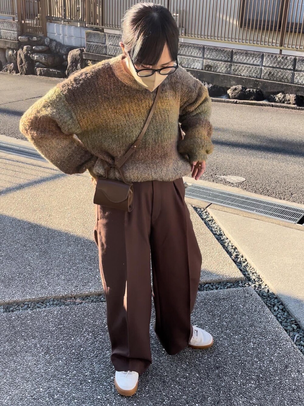 イエロー系のニット/セーター、ブラウン系のスラックスを着用したレディースの秋コーディネートの4枚目の写真
