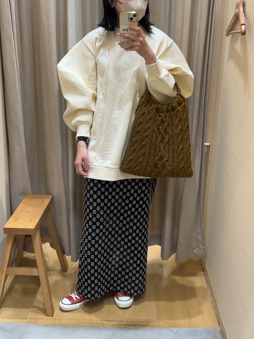 ベージュ系のTシャツ/カットソー、ブラック系のスカート、オレンジ系のスニーカーを着用したレディースの秋コーディネートの2枚目の写真