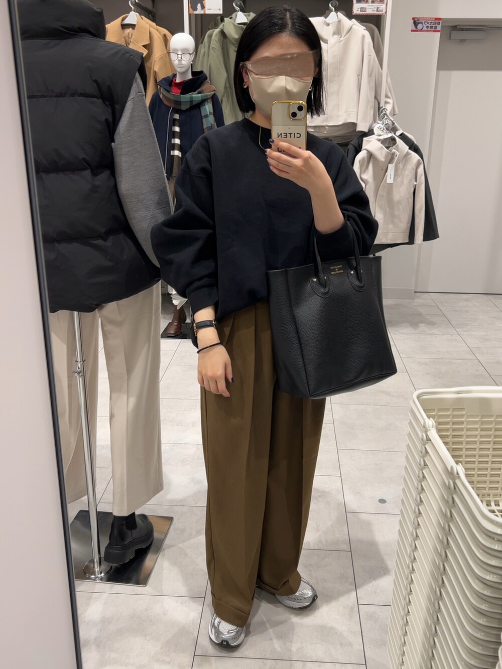 ブラック系のスウェット、ブラウン系のパンツ、シルバー系のスニーカーを着用したレディースの秋コーディネートの2枚目の写真