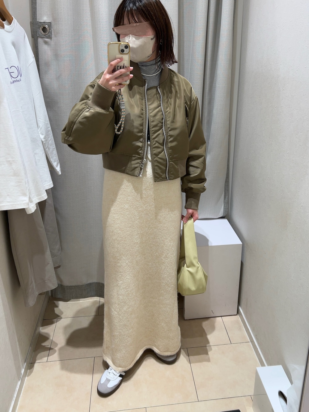 グレー系のTシャツ/カットソー、ホワイト系のワンピース、ベージュ系のショルダーバッグを着用したレディースの冬コーディネートの2枚目の写真