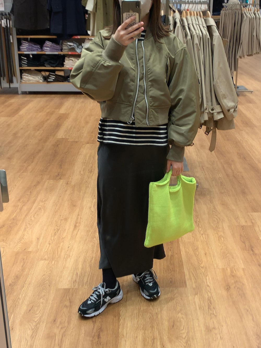 グリーン系のその他アウター、ブラック系のスカート、ブラック系のスニーカーを着用したレディースの春コーディネートの2枚目の写真