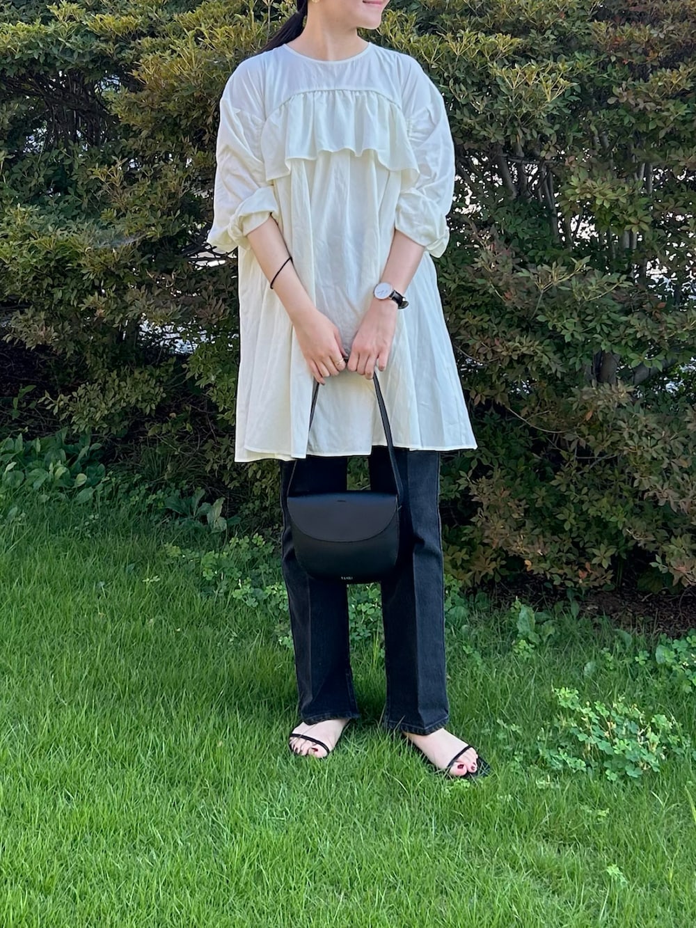 ブラック系のデニムパンツ、ブラック系のトートバッグ、ブラック系のサンダルを着用したレディースの秋コーディネートの2枚目の写真