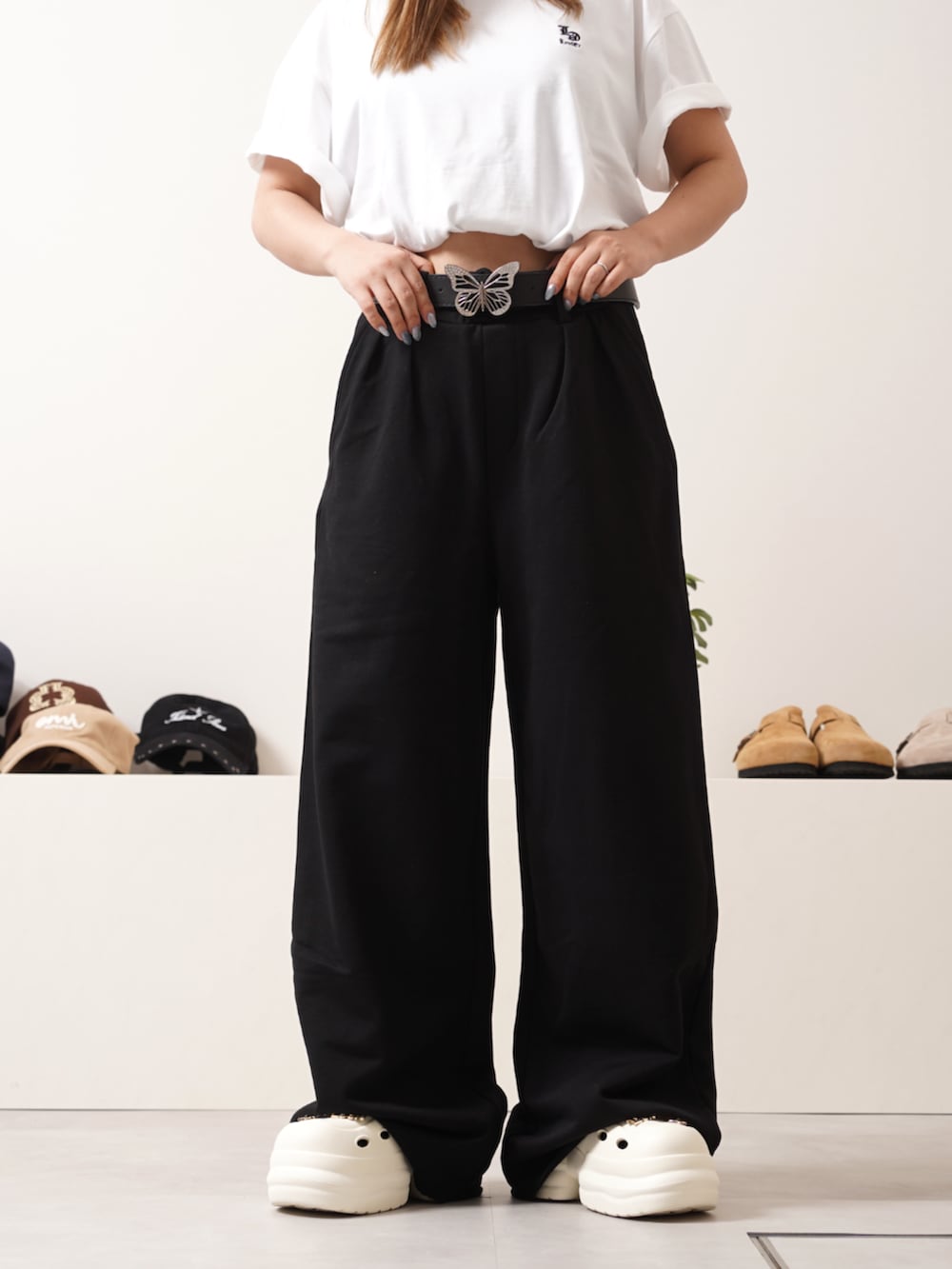 ブラック系のスウェットパンツ、ホワイト系のTシャツ/カットソー、ホワイト系のサンダルを着用したレディースの夏コーディネートの3枚目の写真