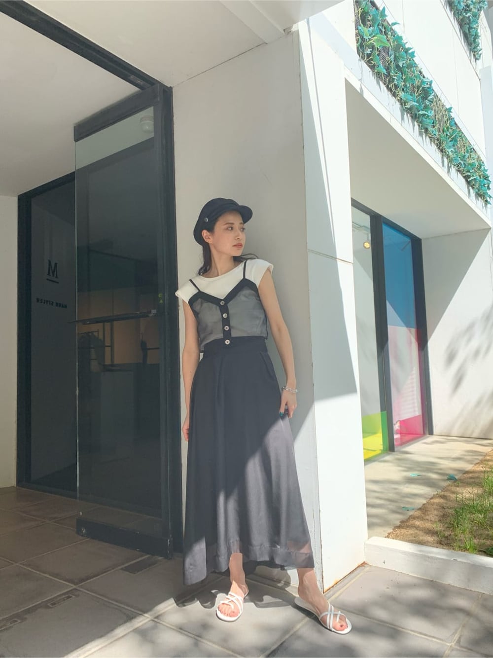 ホワイト系のサンダル、ブラック系のスカート、ブラック系のTシャツ/カットソーを着用したレディースの夏コーディネートの2枚目の写真