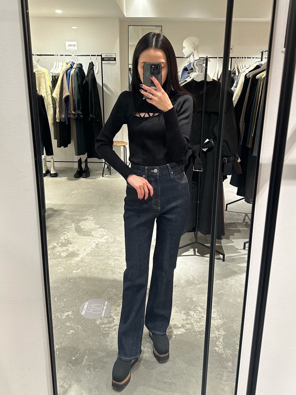 ブラック系のブーツ、ブラック系のチェスターコート、ブラック系のニット/セーターを着用したレディースの冬コーディネートの5枚目の写真