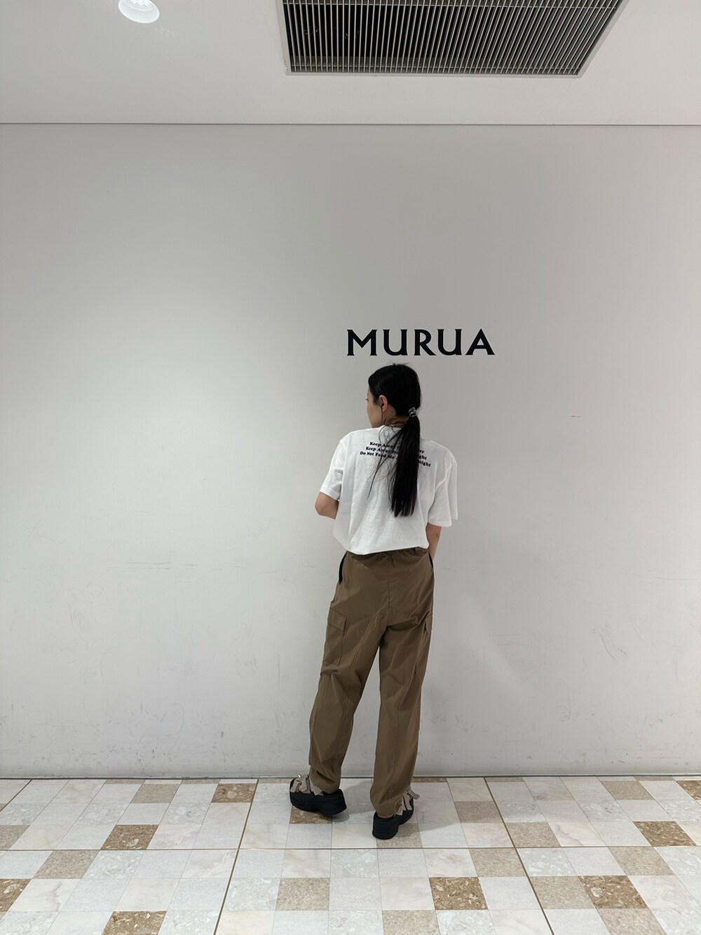 グリーン系のカーゴパンツ、ホワイト系のTシャツ/カットソー、ベージュ系のサンダルを着用したレディースの春コーディネートの3枚目の写真