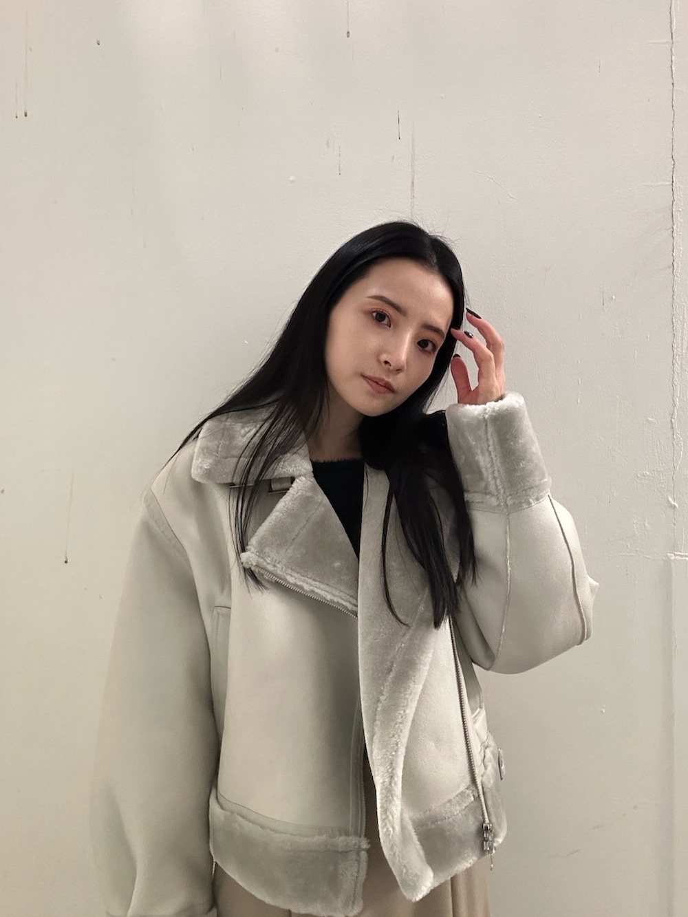 ベージュ系のスカート、グレー系のムートンコート、ブラック系のニット/セーターを着用したレディースの冬コーディネートの4枚目の写真