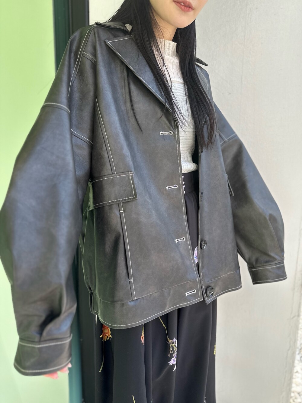 グレー系のブルゾン、ブラック系のスカート、ブラック系のブーツを着用したレディースの冬コーディネートの4枚目の写真