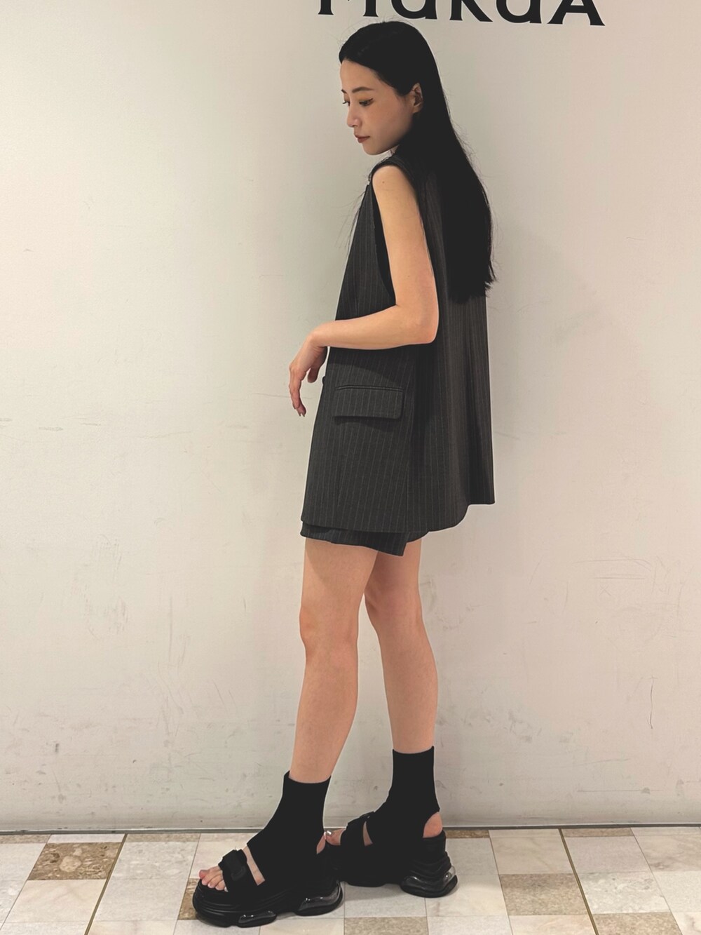 グレー系のその他パンツ、グレー系のベスト、ブルー系のタンクトップを着用したレディースの夏コーディネートの2枚目の写真