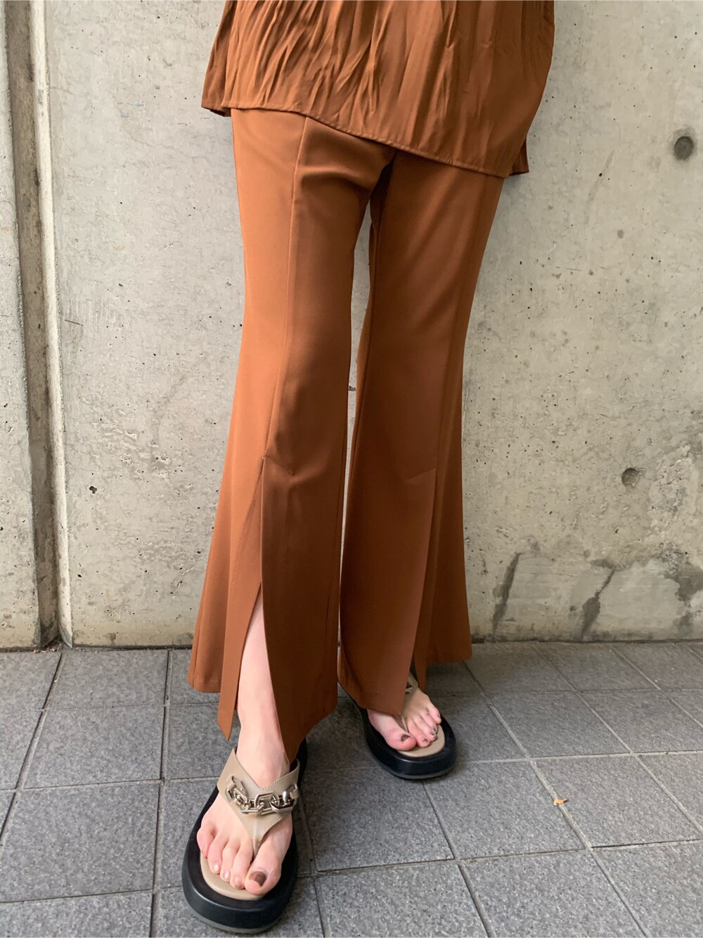 ブラック系のTシャツ/カットソー、ブラウン系のスラックス、ブラック系のハットを着用したレディースの春コーディネートの5枚目の写真