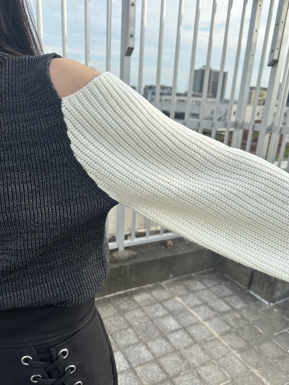 ブラック系のニット/セーター、ブラック系のスカート、ブラック系のブーツを着用したレディースの夏コーディネートの10枚目の写真