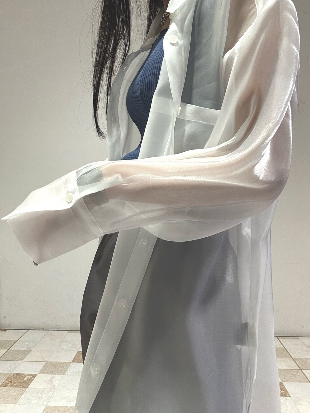 グレー系のスカート、ホワイト系のシャツ/ブラウス、ブルー系のタンクトップを着用したレディースの春コーディネートの5枚目の写真