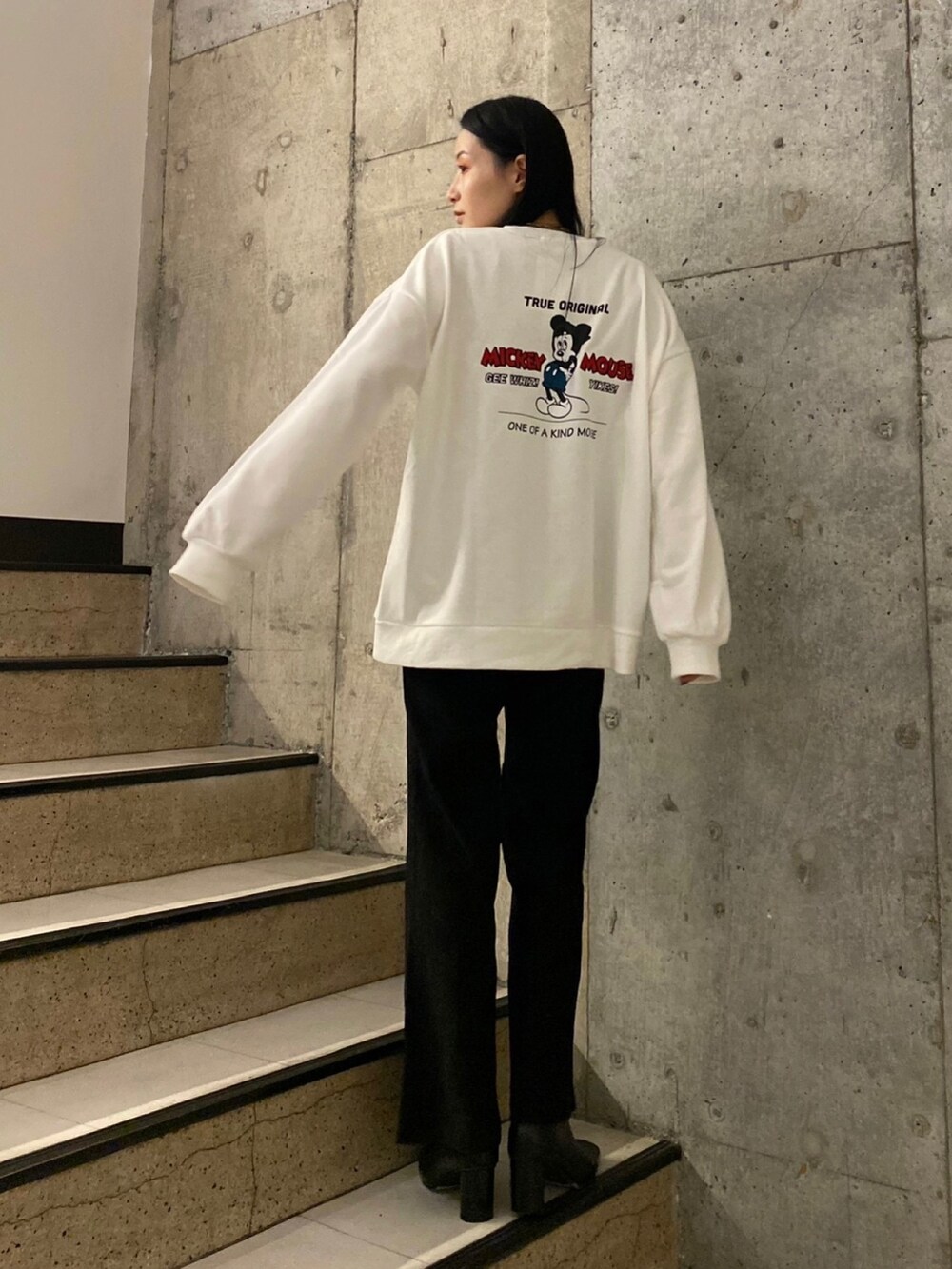 ホワイト系のスウェット、ブラック系のその他パンツ、ブラック系のブーツを着用したレディースの秋コーディネートの2枚目の写真