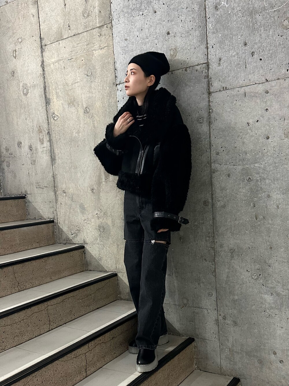 ブラック系のムートンコート、その他のニット/セーター、ブラック系のデニムパンツを着用したレディースの秋コーディネートの2枚目の写真