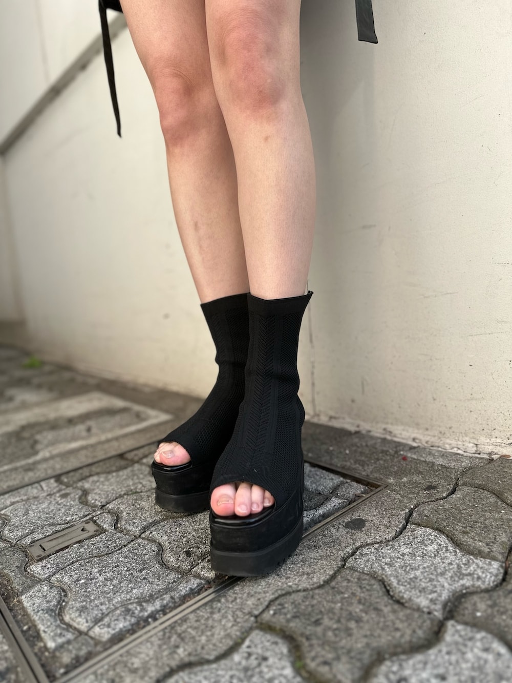 ベージュ系のスカート、ブラック系のTシャツ/カットソー、ブラック系のブーツを着用したレディースの冬コーディネートの7枚目の写真