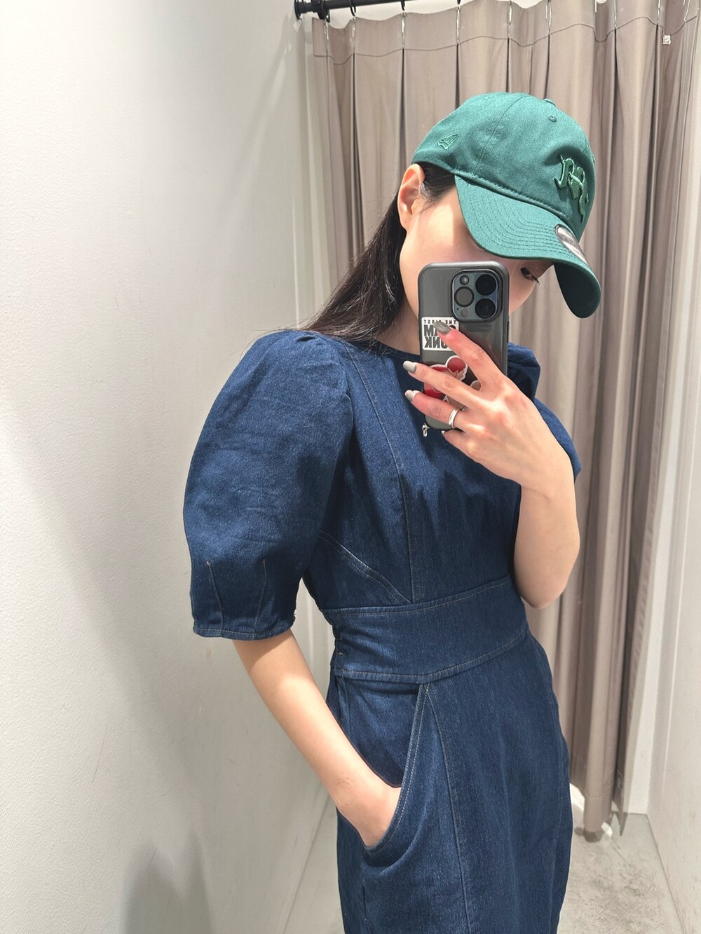 ブルー系のワンピース、ブラック系のサンダル、グリーン系のキャップを着用したレディースの春コーディネートの2枚目の写真