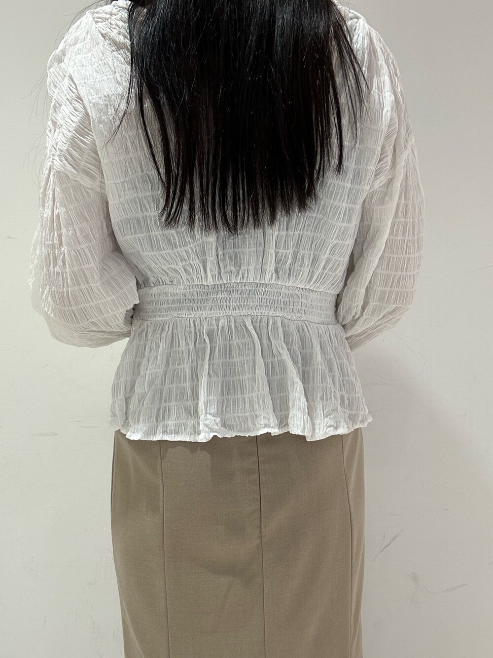 ホワイト系のシャツ/ブラウス、ベージュ系のスカート、ブラック系のブーツを着用したレディースの春コーディネートの7枚目の写真