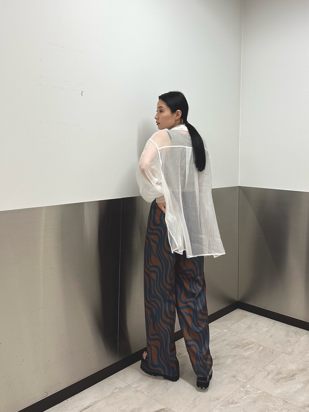 ホワイト系のシャツ/ブラウス、ブルー系のスラックス、ベージュ系のTシャツ/カットソーを着用したレディースの夏コーディネートの3枚目の写真