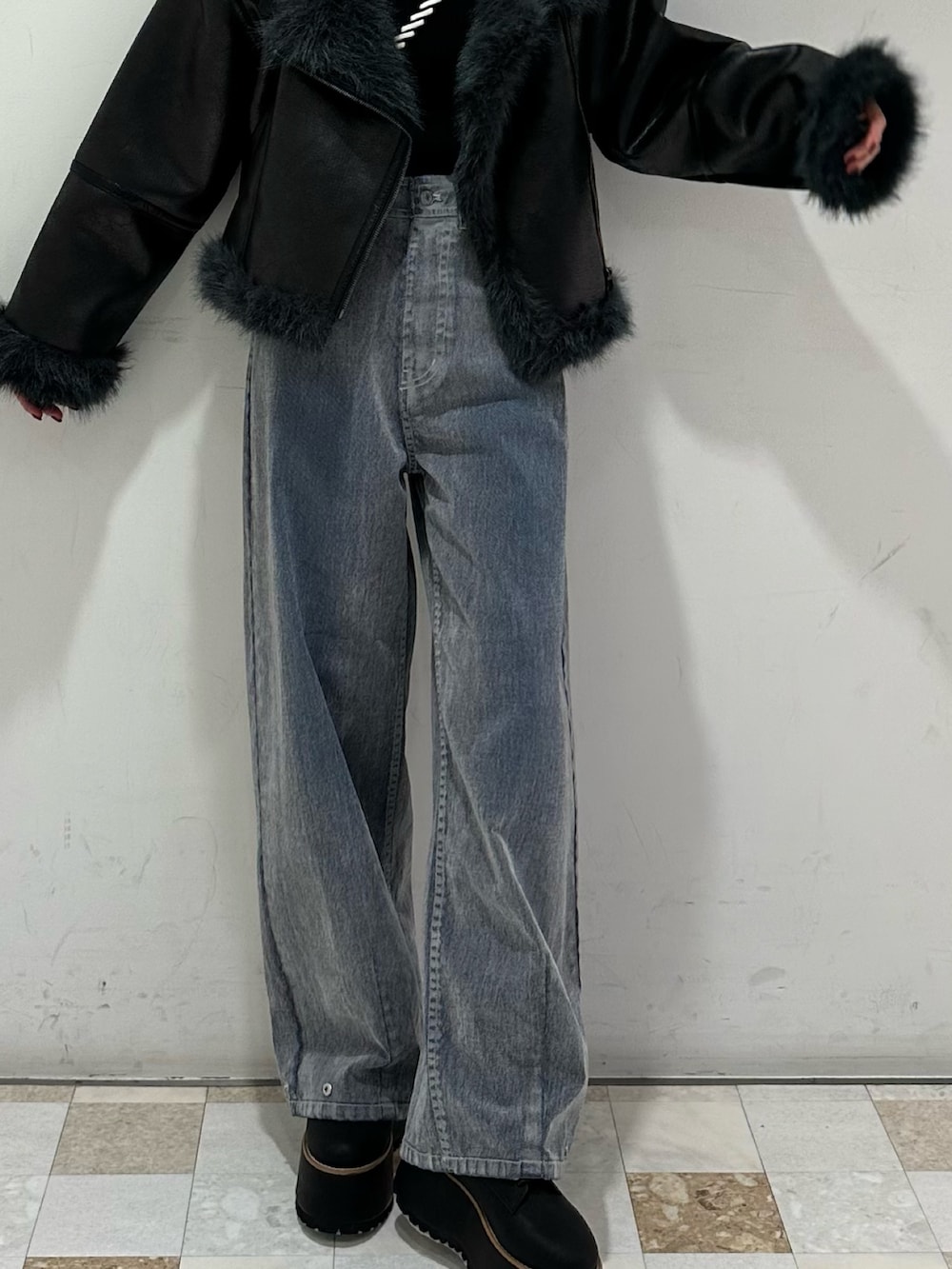 グレー系のデニムパンツ、ブラック系のブーツ、ブラック系のムートンコートを着用したレディースの夏コーディネートの4枚目の写真
