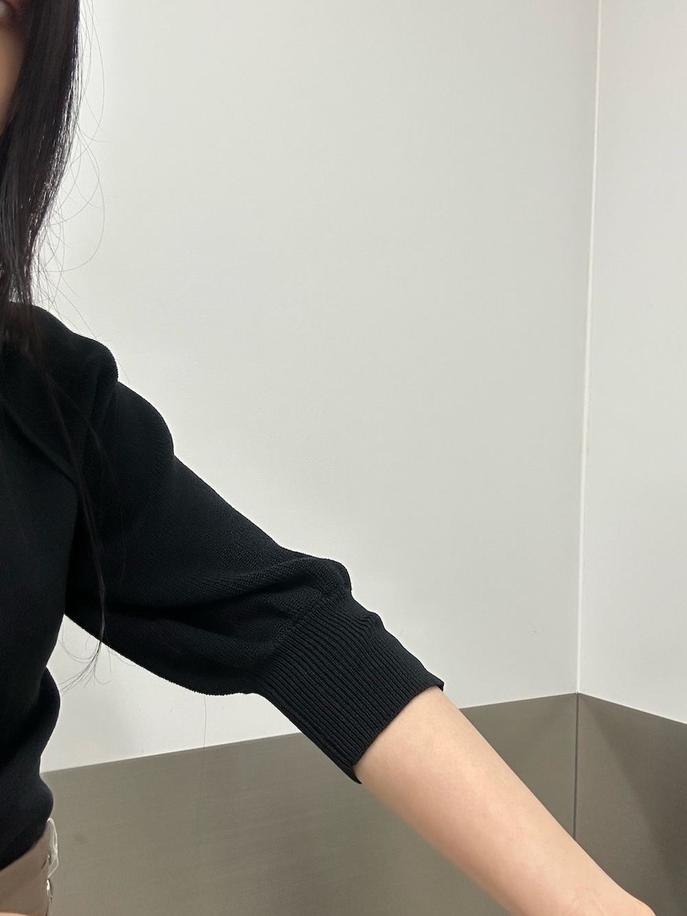 ベージュ系のスカート、ブラック系のニット/セーター、ブラック系のブーツを着用したレディースの夏コーディネートの7枚目の写真