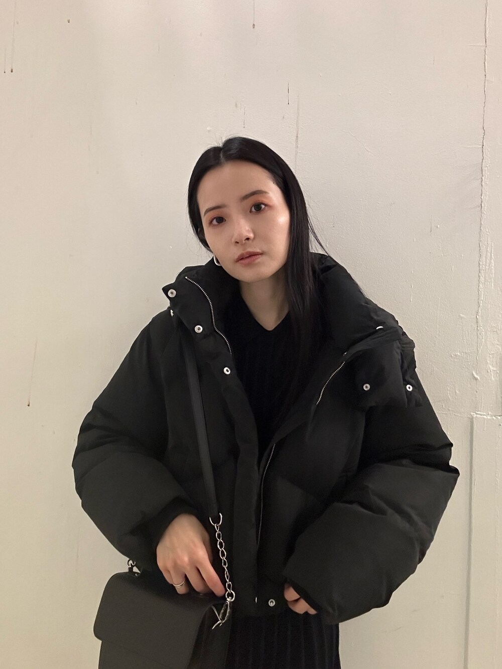 ブラック系のダウンジャケット/コート、ブラック系のブーツ、ブラック系のワンピースを着用したレディースの冬コーディネートの5枚目の写真